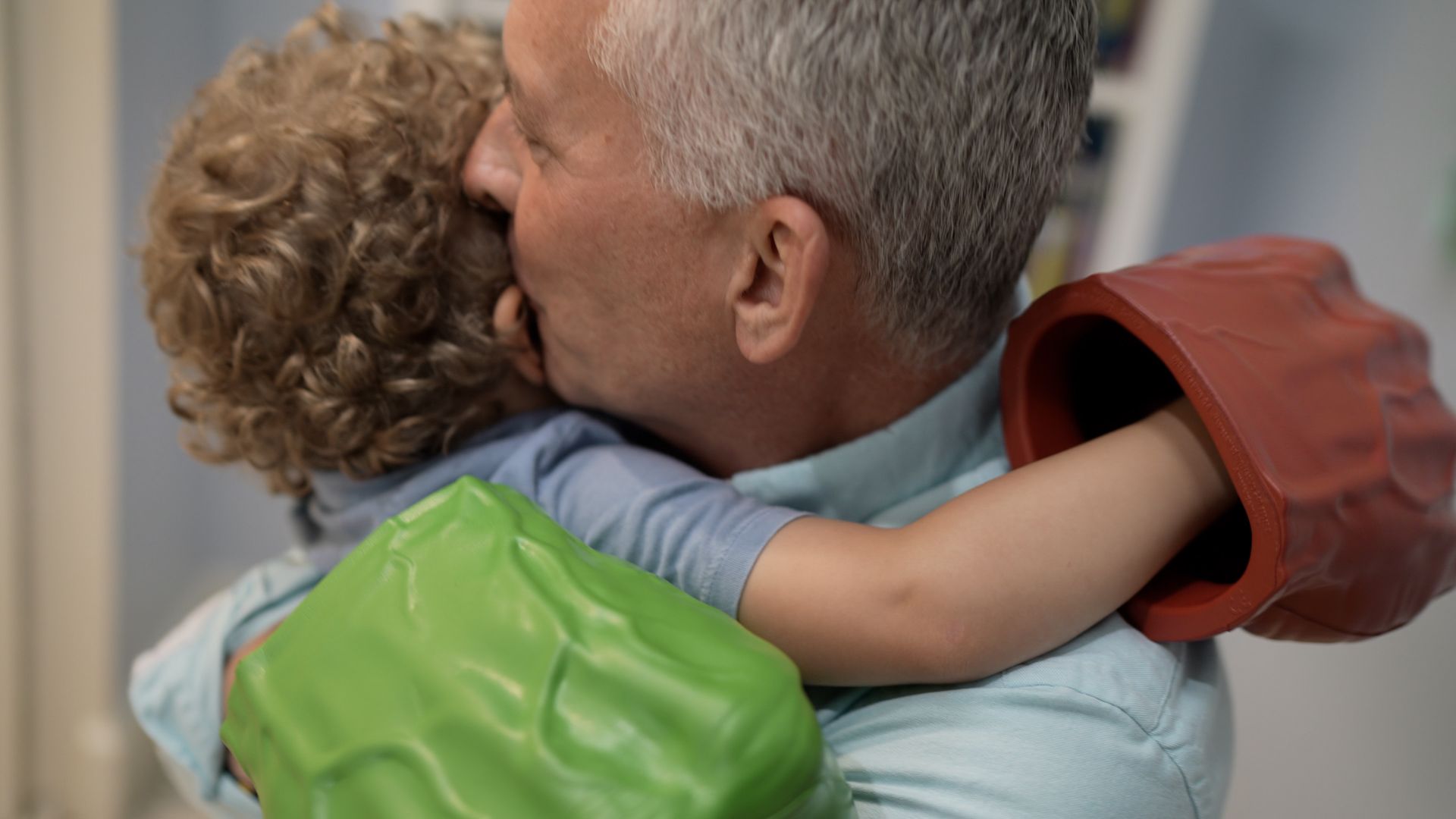 David embraces a young child in a green jacket